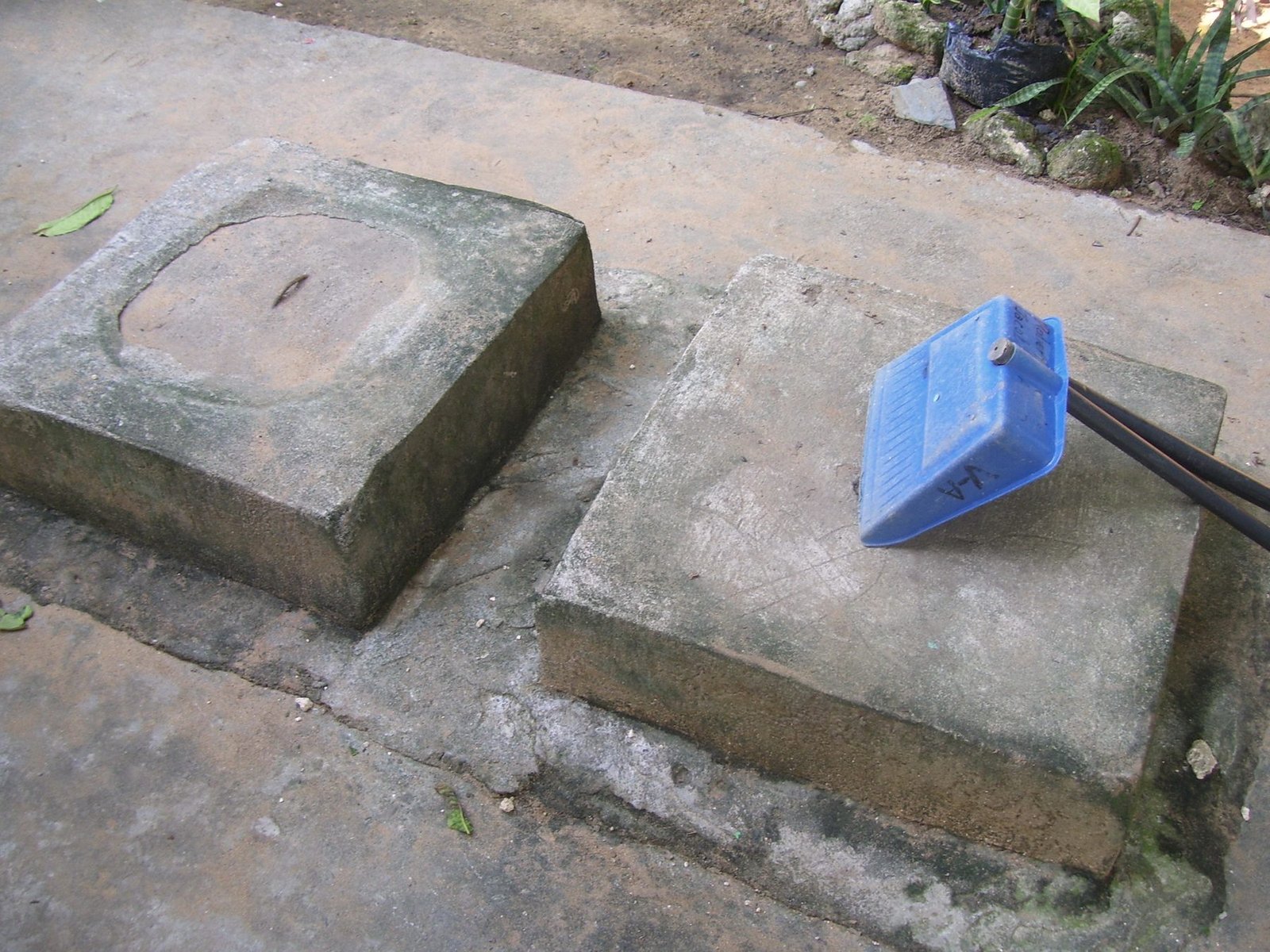 Two square concrete tank covers at ground level