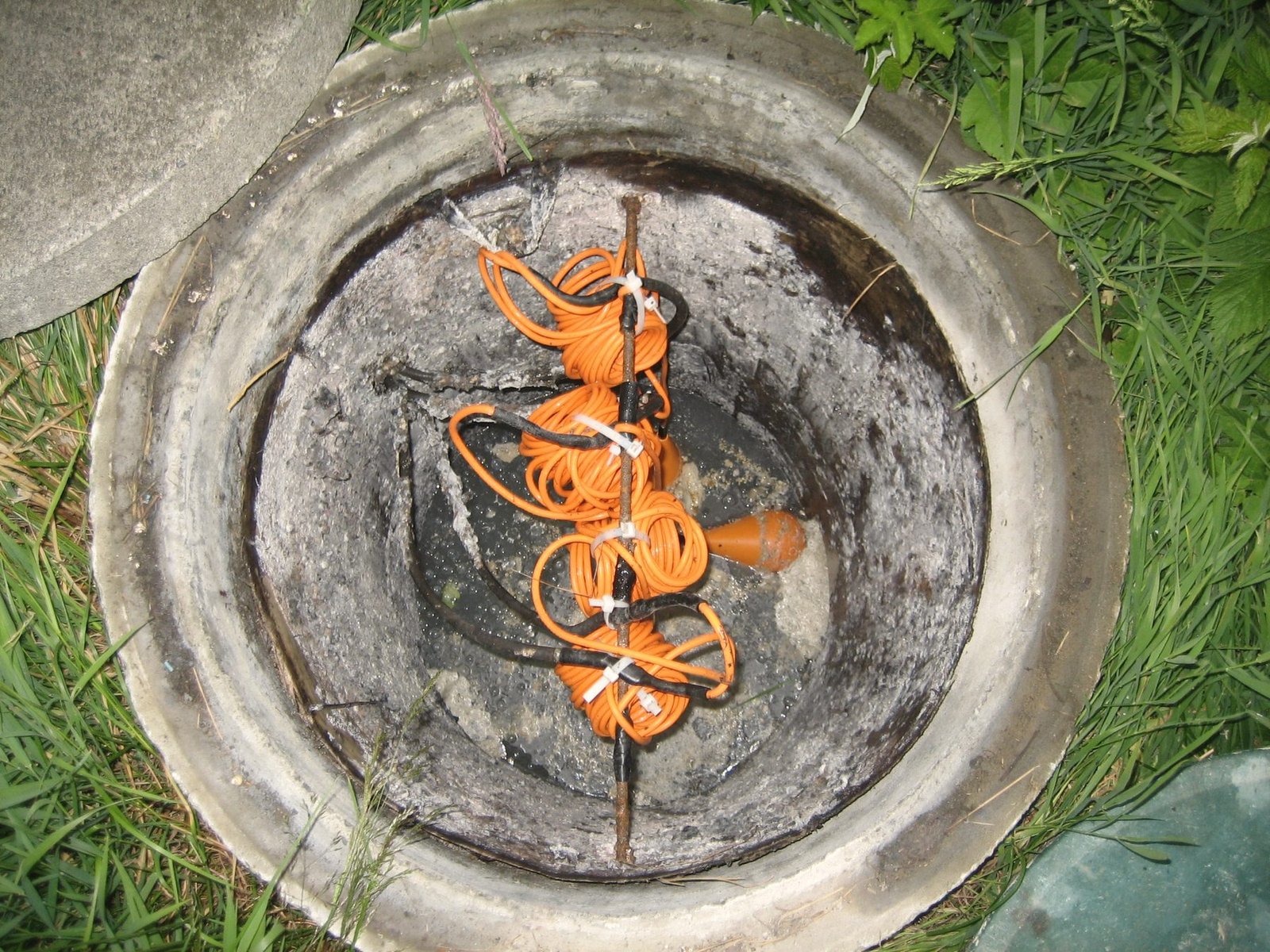 Looking down into a round tank opening with an orange outlet fitting